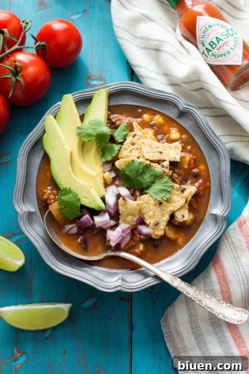 Fully Loaded Chorizo Taco Soup 3 A close-up of Chorizo Taco Soup with a spoon, highlighting its rich texture and ingredients