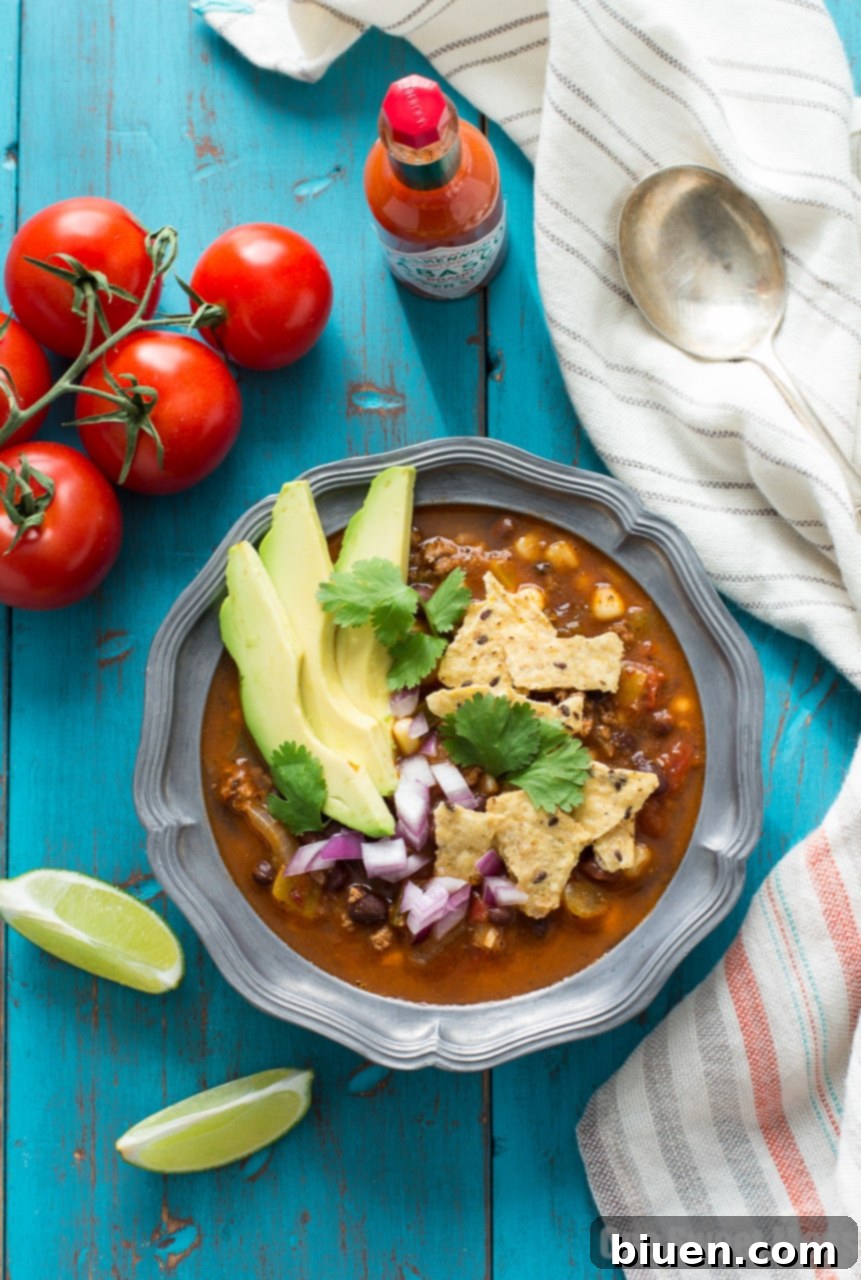 Fully Loaded Chorizo Taco Soup 5 A bowl of Chorizo Taco Soup with tortilla chips and a lime wedge