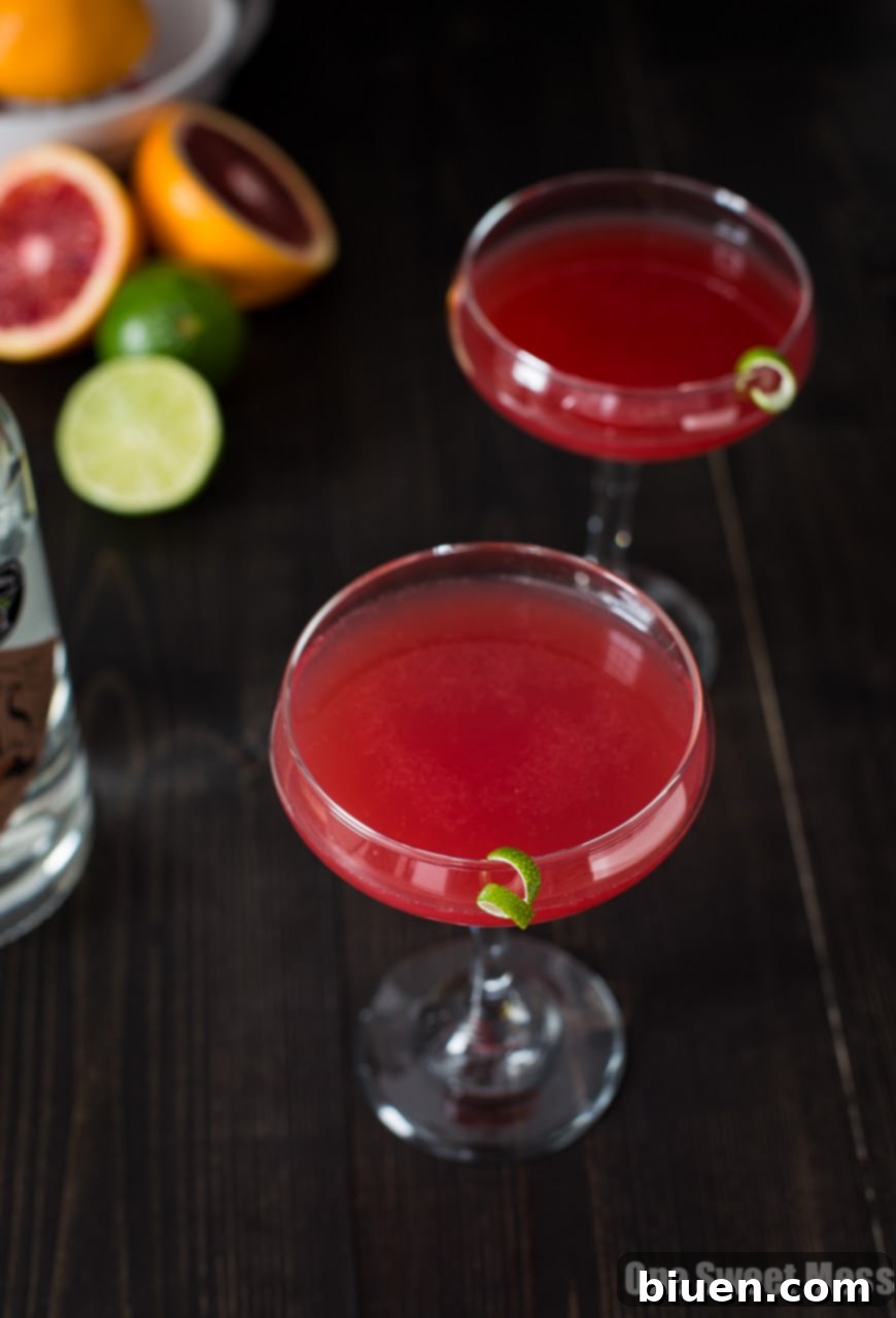 Blood Orange Cosmo Cocktail in a coupe glass, garnished with a blood orange slice.