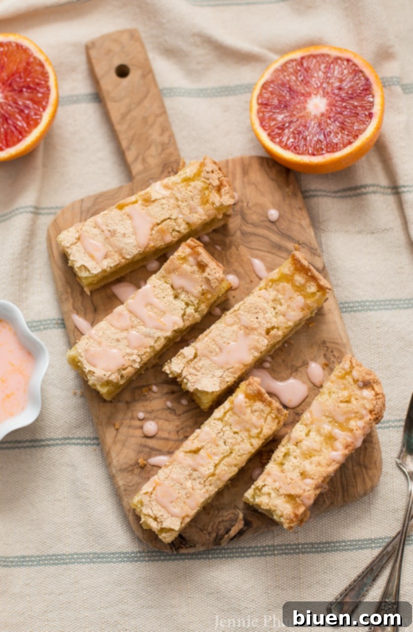 Blood Orange Jewel Bites, Vanilla Cloud Kiss 4 A stack of Blood Orange Bars, perfectly cut and ready to serve, highlighting their thick texture and inviting glaze