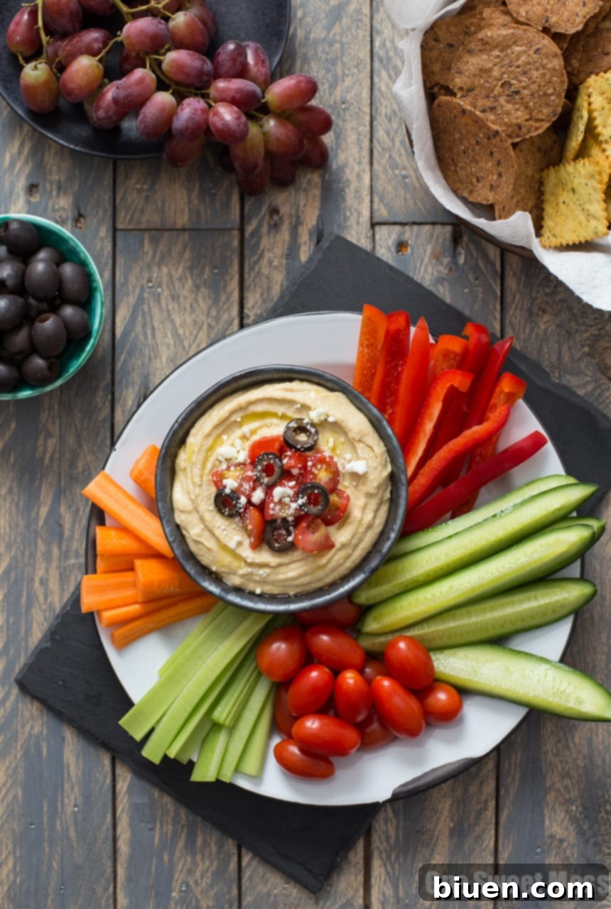 Traditional Greek Hummus Mezze 2 Greek Hummus Platter with vibrant toppings including tomatoes, feta, and olives
