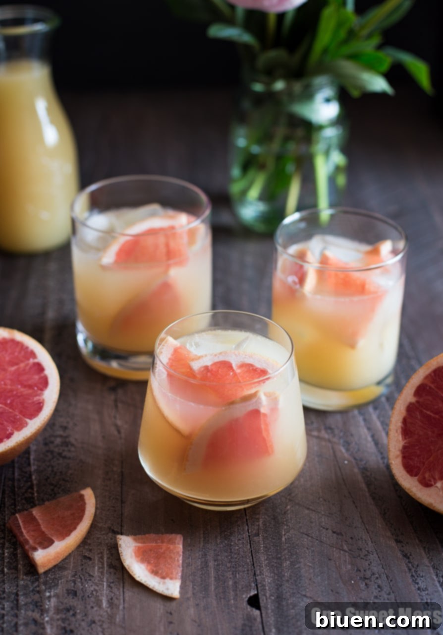 Close-up of a Bourbon Grapefruit Cocktail with ice and a sprig of rosemary