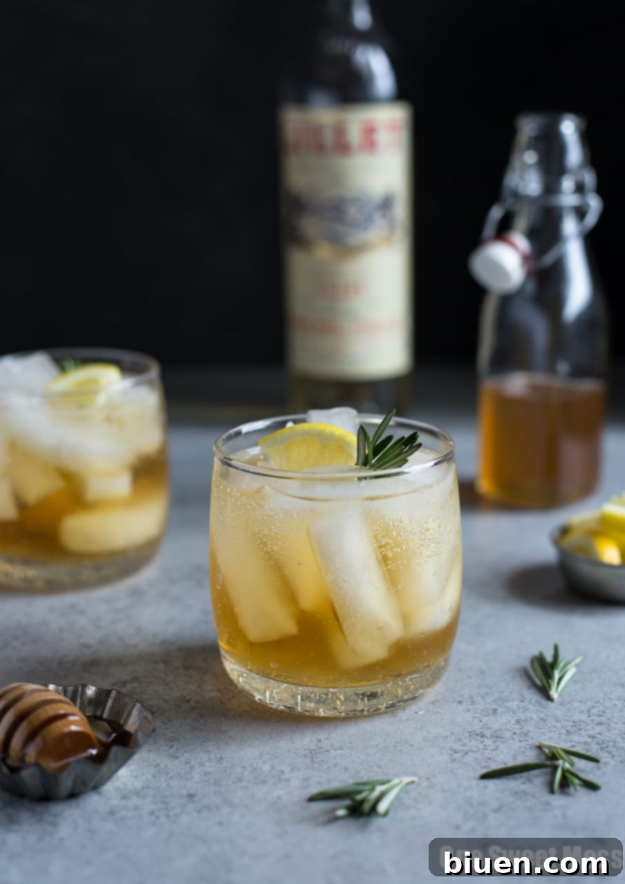 Honey Rosemary Lillet Spritzer cocktail garnished with rosemary and orange