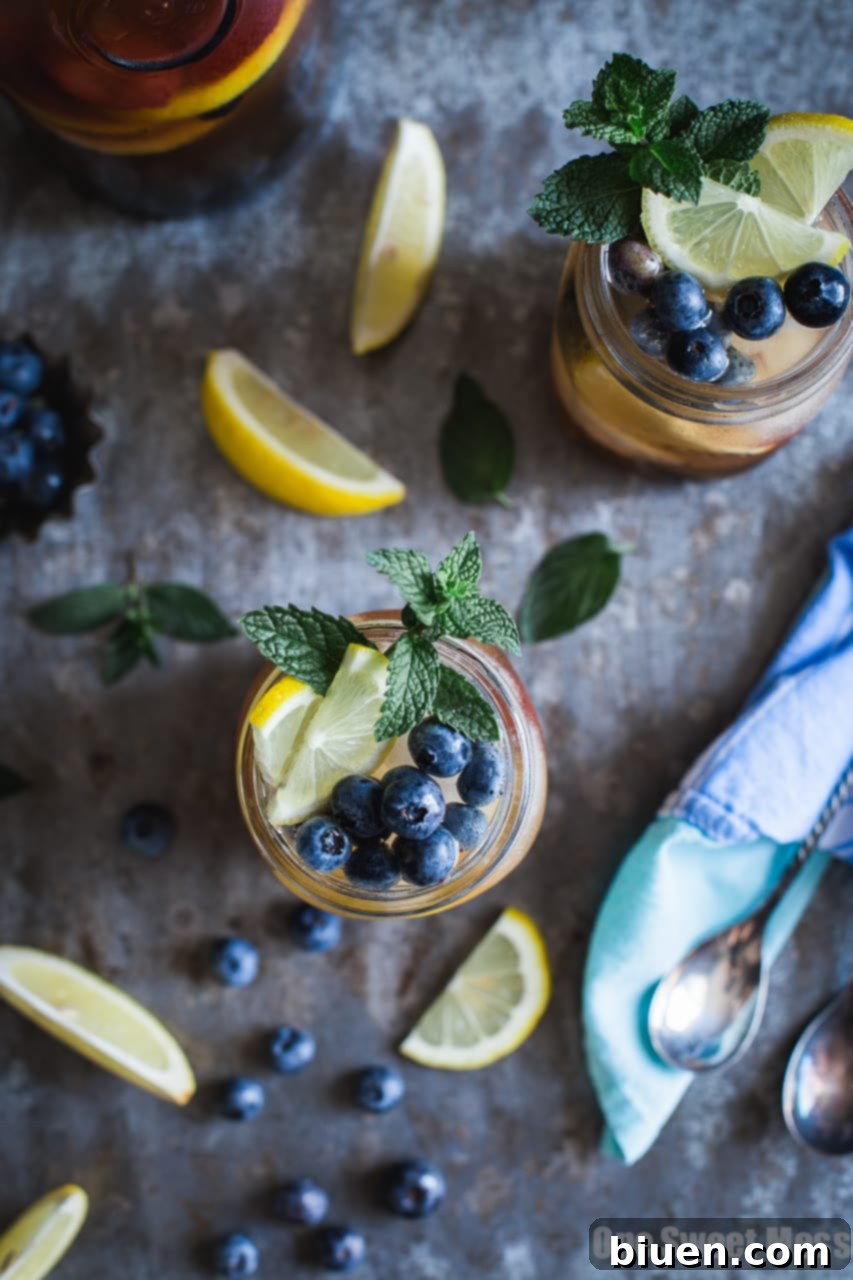 Blueberry Sweet Tea Lemonade Sangria being poured into glasses with ice and fruit
