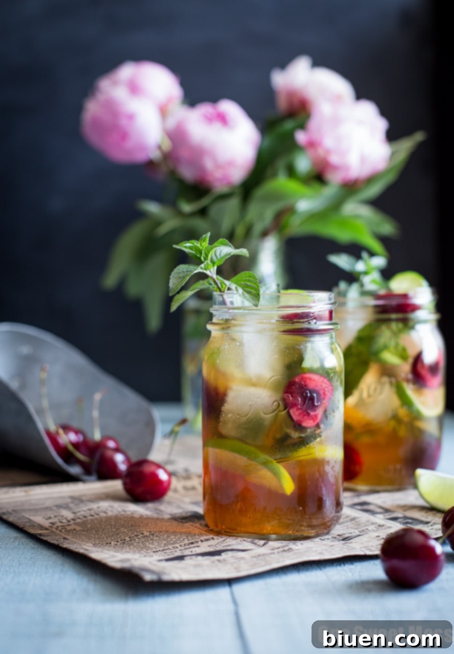 Black Cherry Mule, a refreshing summer cocktail served in a frosty mason jar with fresh cherries and mint garnish.