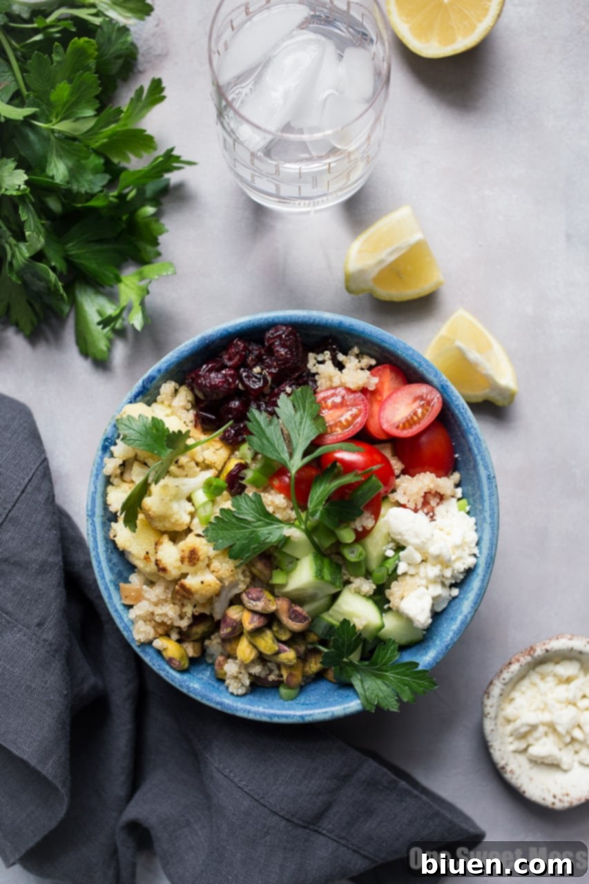 Close-up of a vibrant Roasted Cauliflower Quinoa Salad with Lemon Tahini Dressing, garnished with fresh herbs, ready to be served