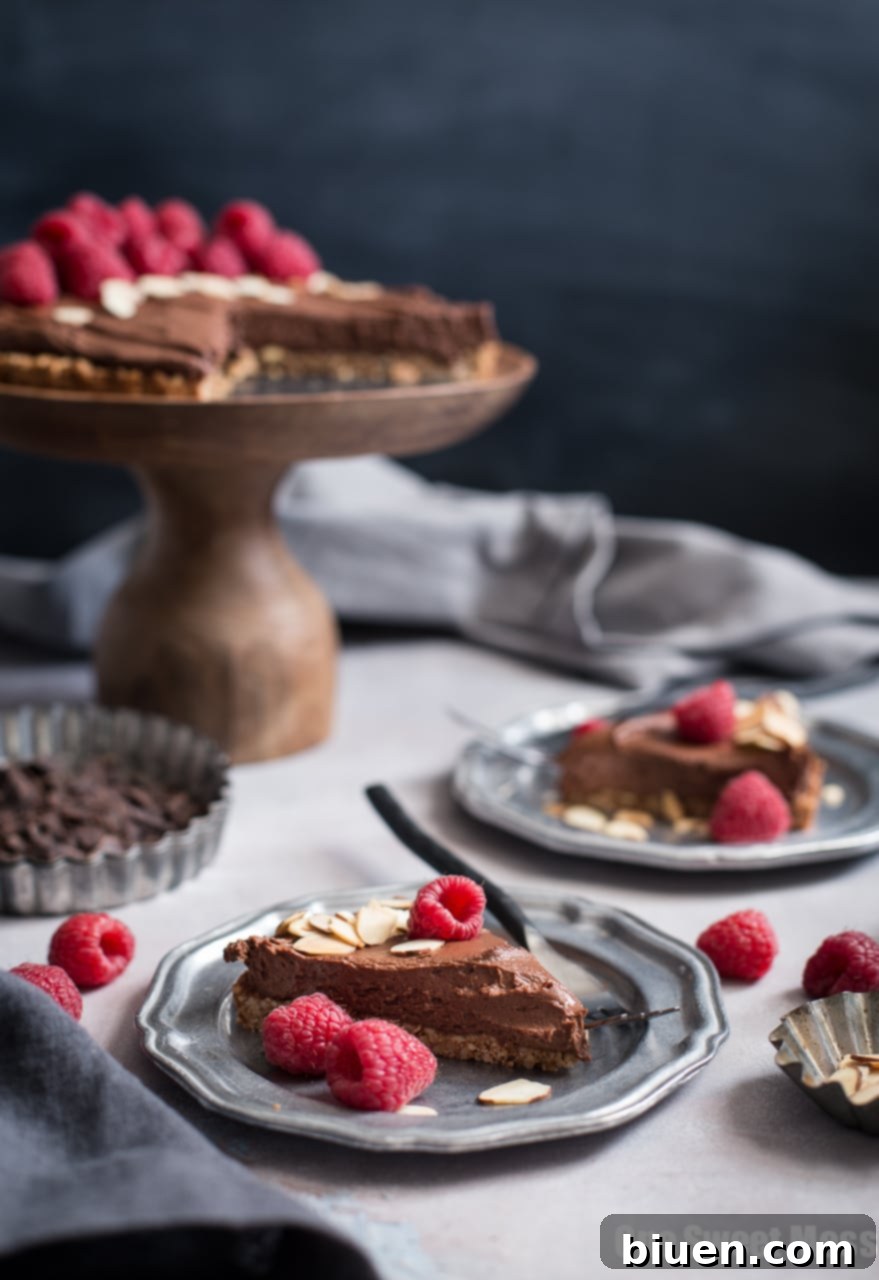 Decadent Vegan Gluten-Free Dark Chocolate Almond Tart 5 A large Dark Chocolate Almond Tart, showcasing its glossy chocolate filling and rustic almond crust. An excellent vegan, gluten-free, and dairy-free dessert for any occasion.