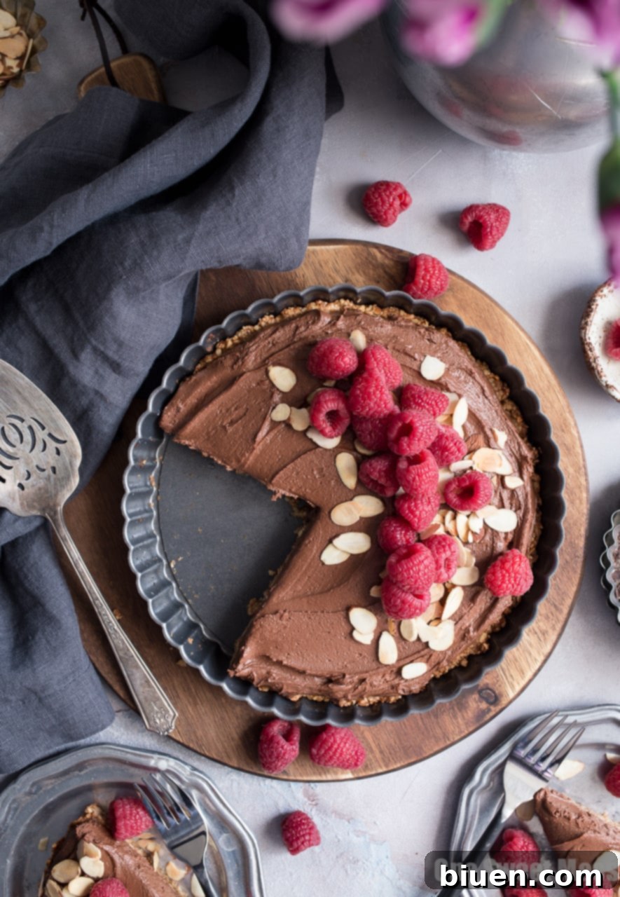 Decadent Vegan Gluten-Free Dark Chocolate Almond Tart 6 A close-up of a generous slice of Dark Chocolate Almond Tart, showing the thick, creamy chocolate filling and the perfectly baked, crunchy almond crust. Vegan, gluten-free, and perfect for Valentine's Day.