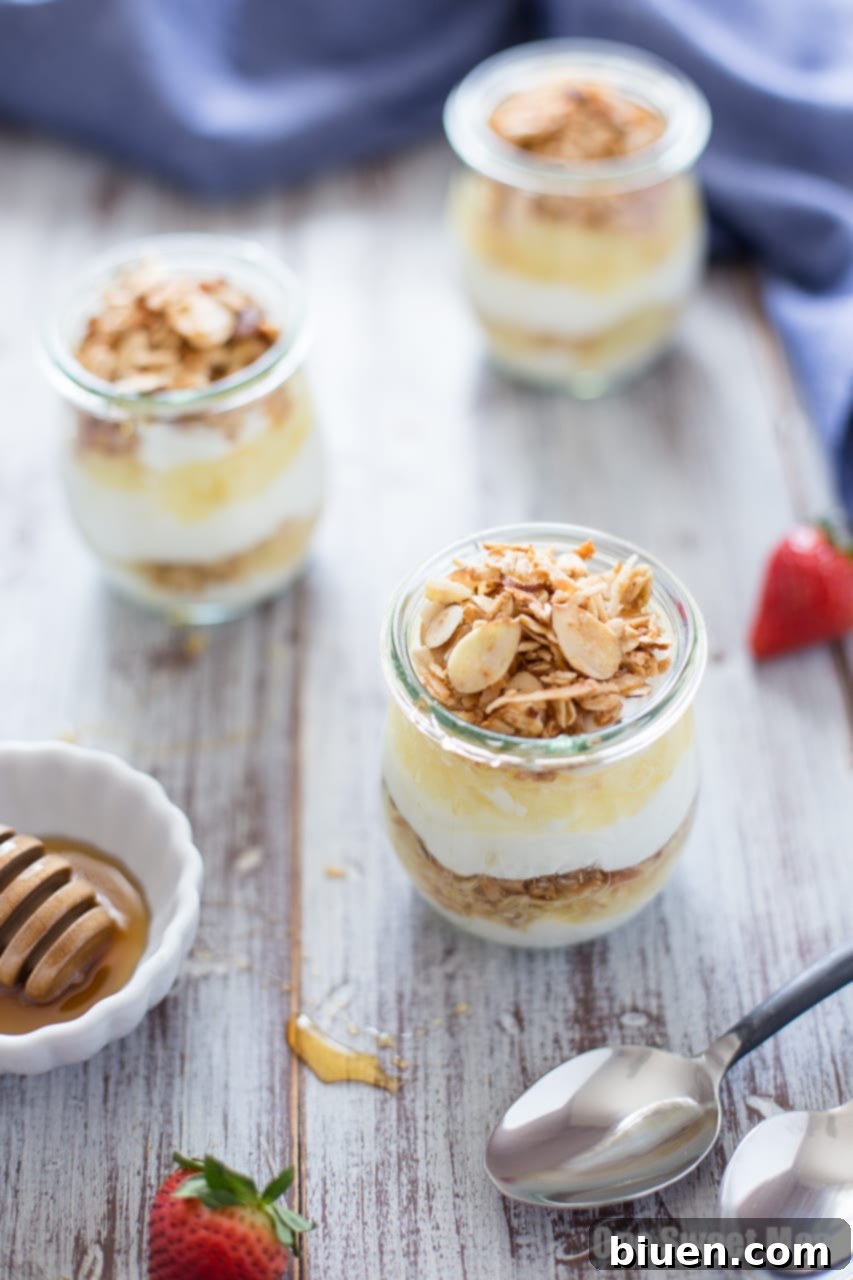Close-up of a Pina Colada Yogurt and Honey Parfait in a jar, showcasing layers of creamy yogurt, golden granola, and sweet pineapple.