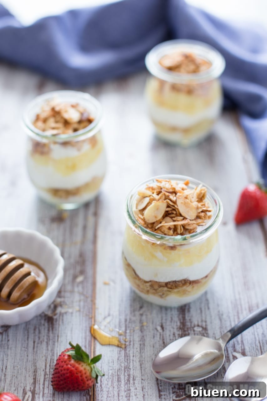 Assembled Pina Colada Yogurt and Honey Parfait, topped with a generous drizzle of golden honey.