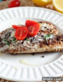 A perfectly cooked Hazelnut Crusted Tilapia fillet drizzled with lemon butter sauce.