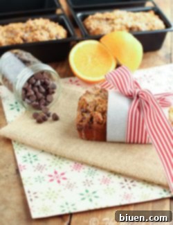 Zesty Orange and Pumpkin Chocolate Chip Loaf with a Sweet Citrus Glaze 2 Overhead view of a mini loaf of Pumpkin Orange Chocolate Chip Bread with orange glaze and a ribbon