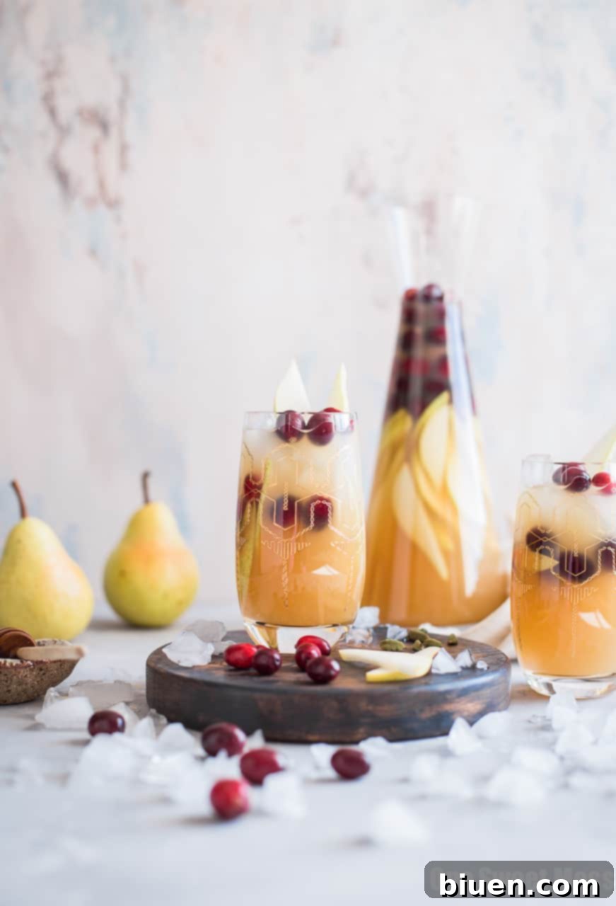 Delicious Honey Pear Cardamom Sangria in a pitcher with fresh fruit