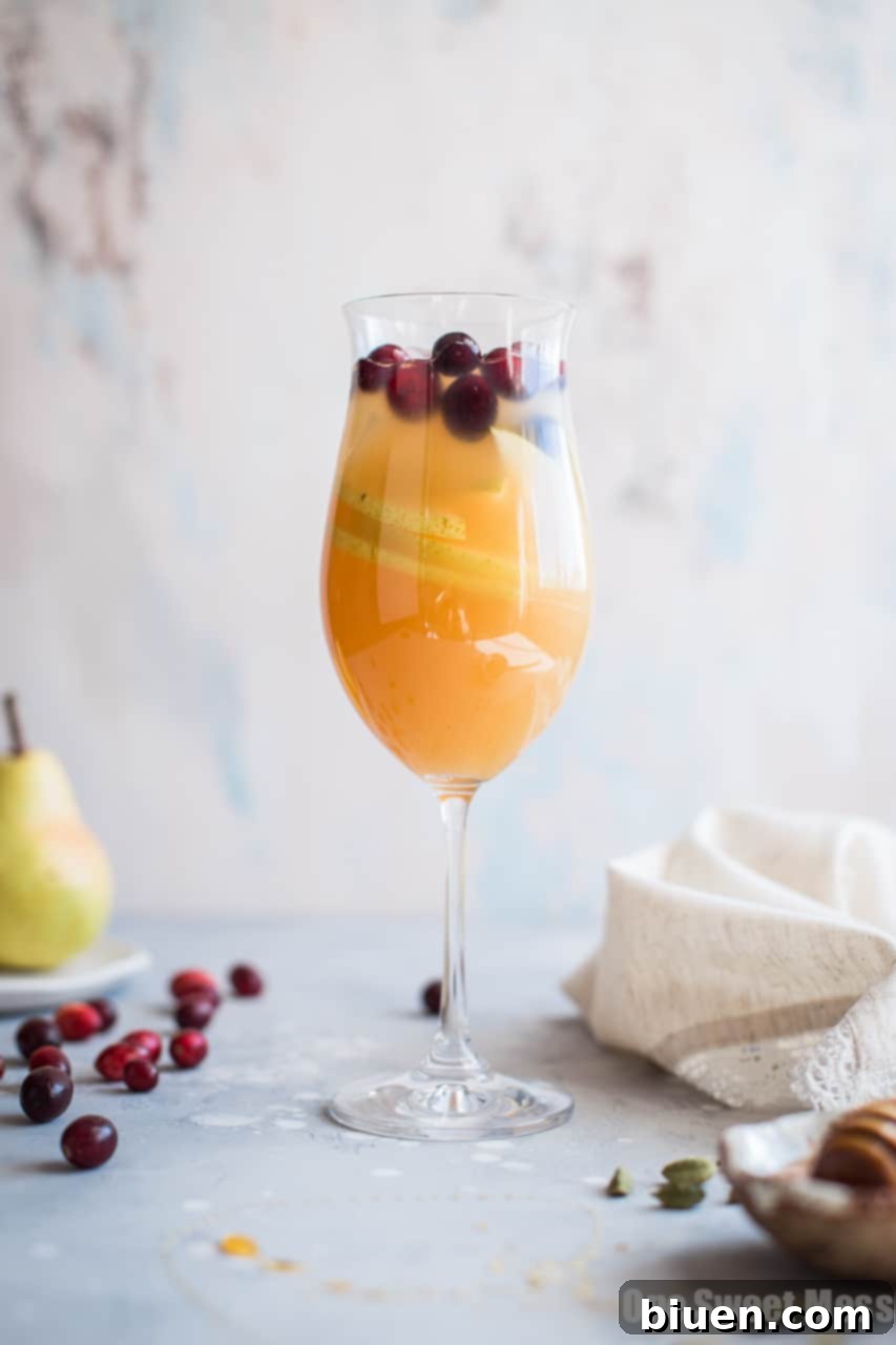 Festive pitcher of Honey Pear Cardamom Sangria ready for serving