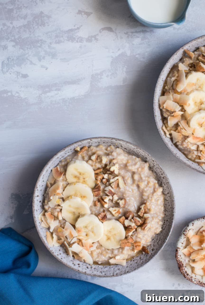 Delicious Banana Bread Steel Cut Oatmeal topped with toasted pecans, coconut flakes, and fresh banana slices, ideal for a healthy gluten-free and vegan breakfast.