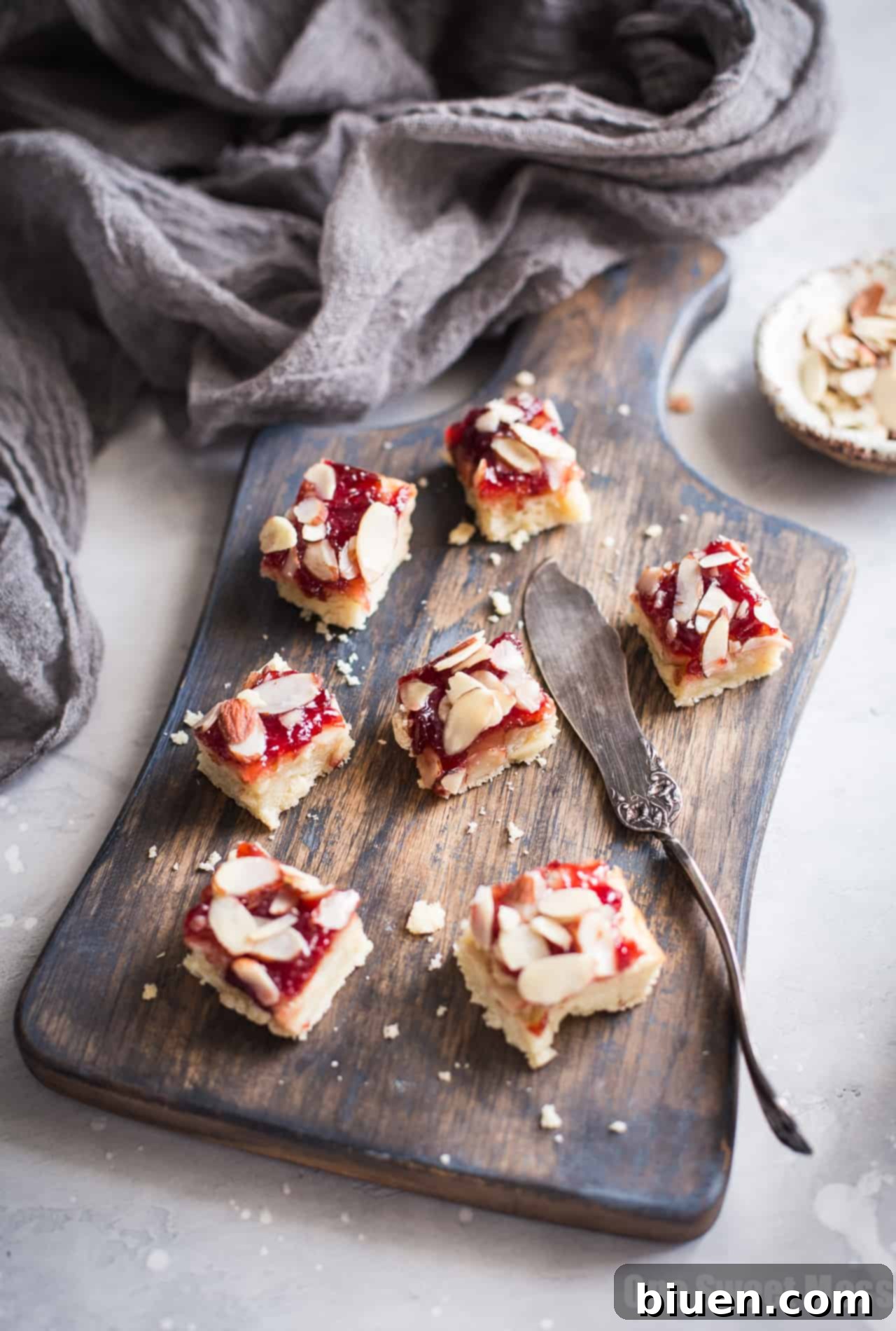 Close-up of Gluten-Free Cherry Almond Shortbread Bars with a corner piece lifted