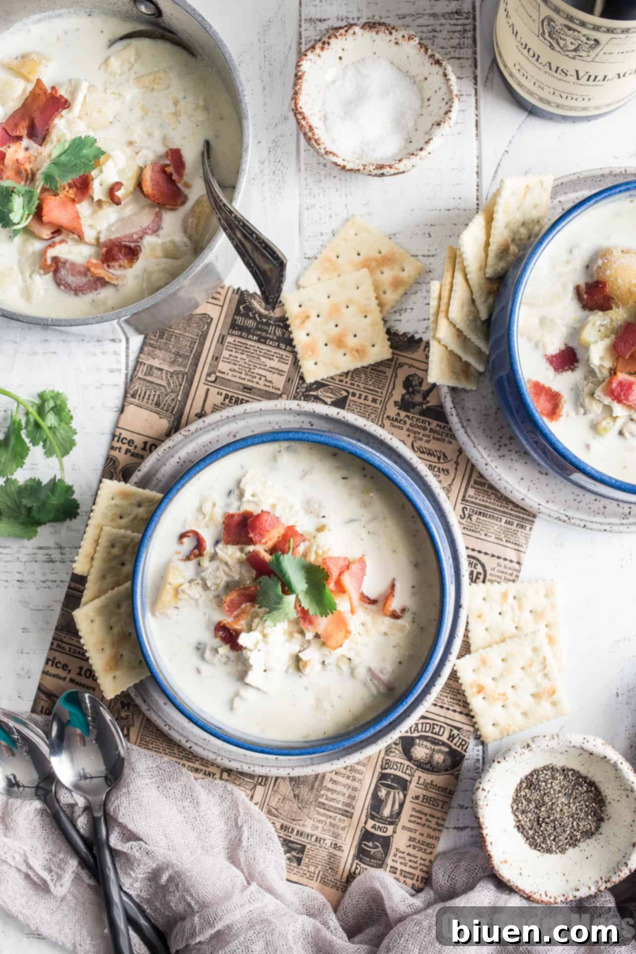 New England Clam Chowder: This thick, hearty, and gluten-free one-pot meal is served in a bowl, garnished with herbs.
