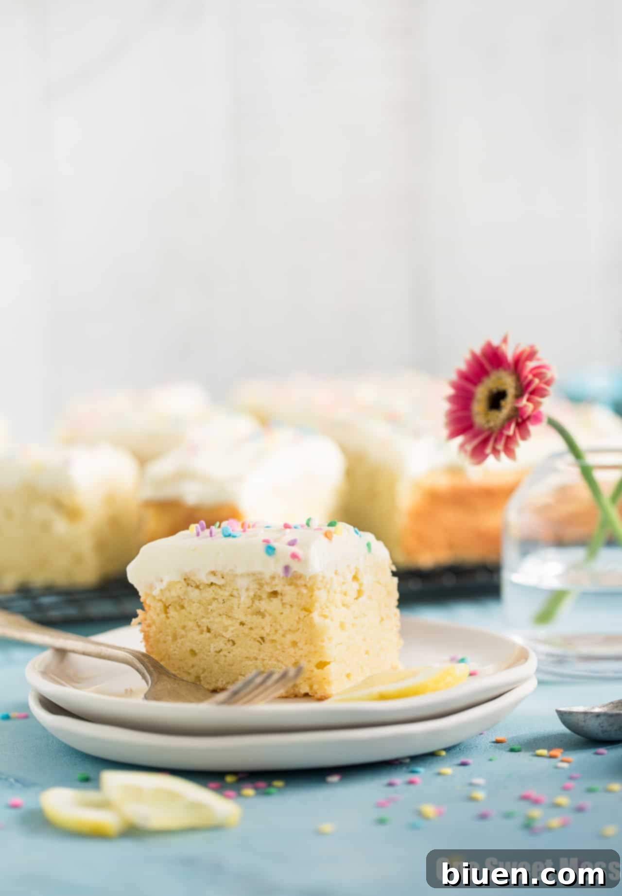 A close-up of a slice of Lemon Buttermilk Cake, showing its moist texture and creamy frosting.