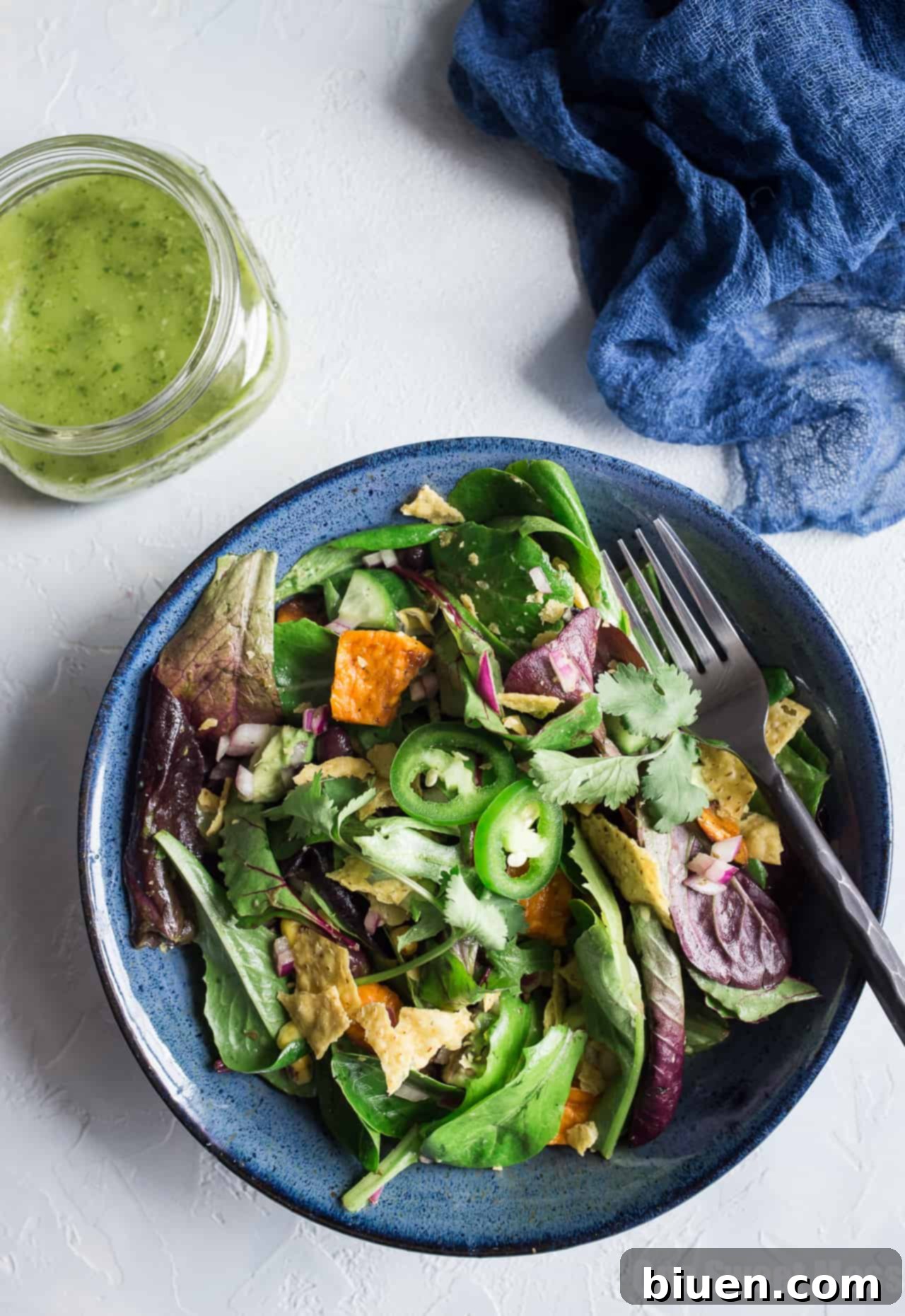 Ingredients for Roasted Sweet Potato and Black Bean Salad, including fresh produce and dressing components, ready for preparation