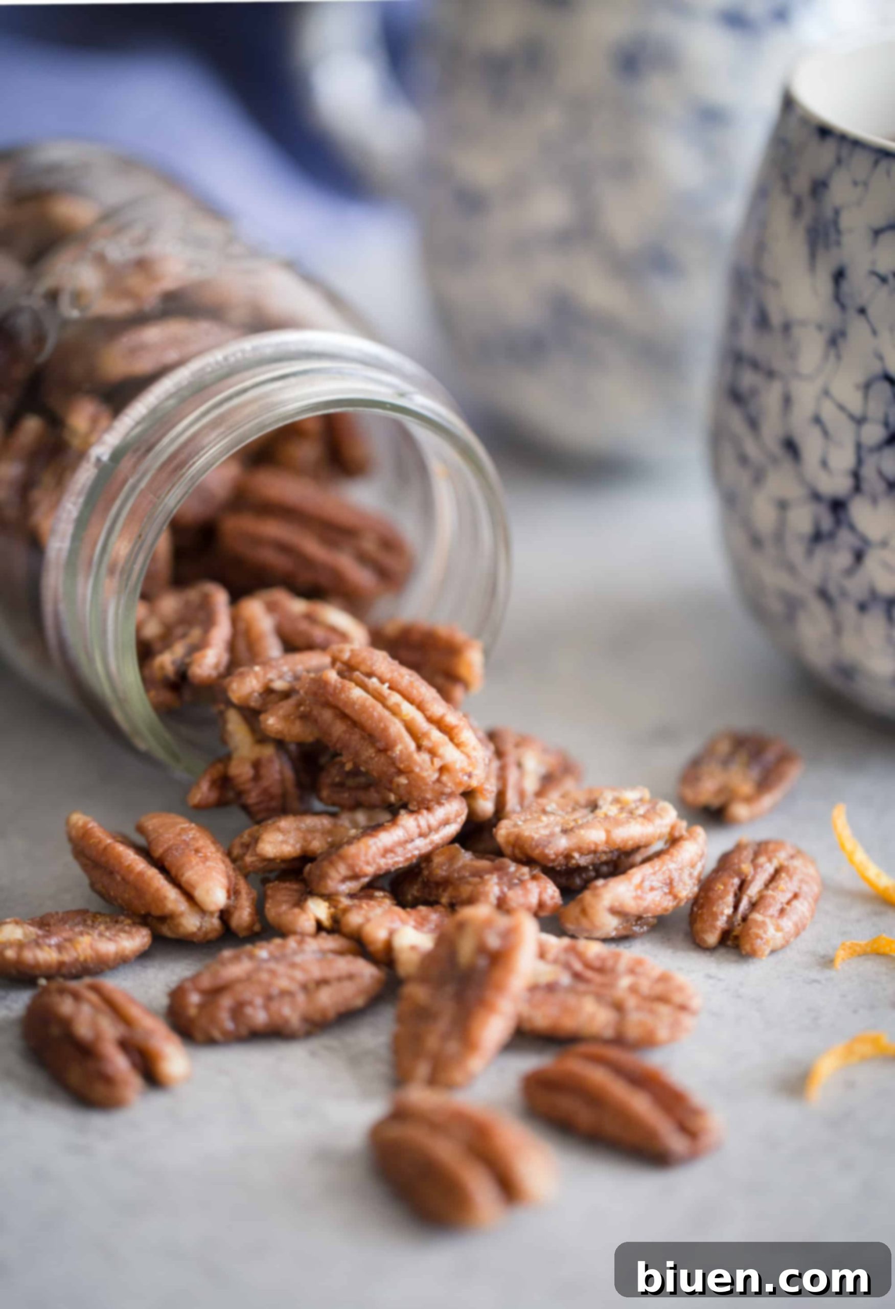 Maple-Orange Glazed Pecans 4 A visual display of the key ingredients for Maple-Orange Roasted Pecans: whole pecans, a bowl of maple syrup, grated orange zest, melted coconut oil, and a separated egg white.