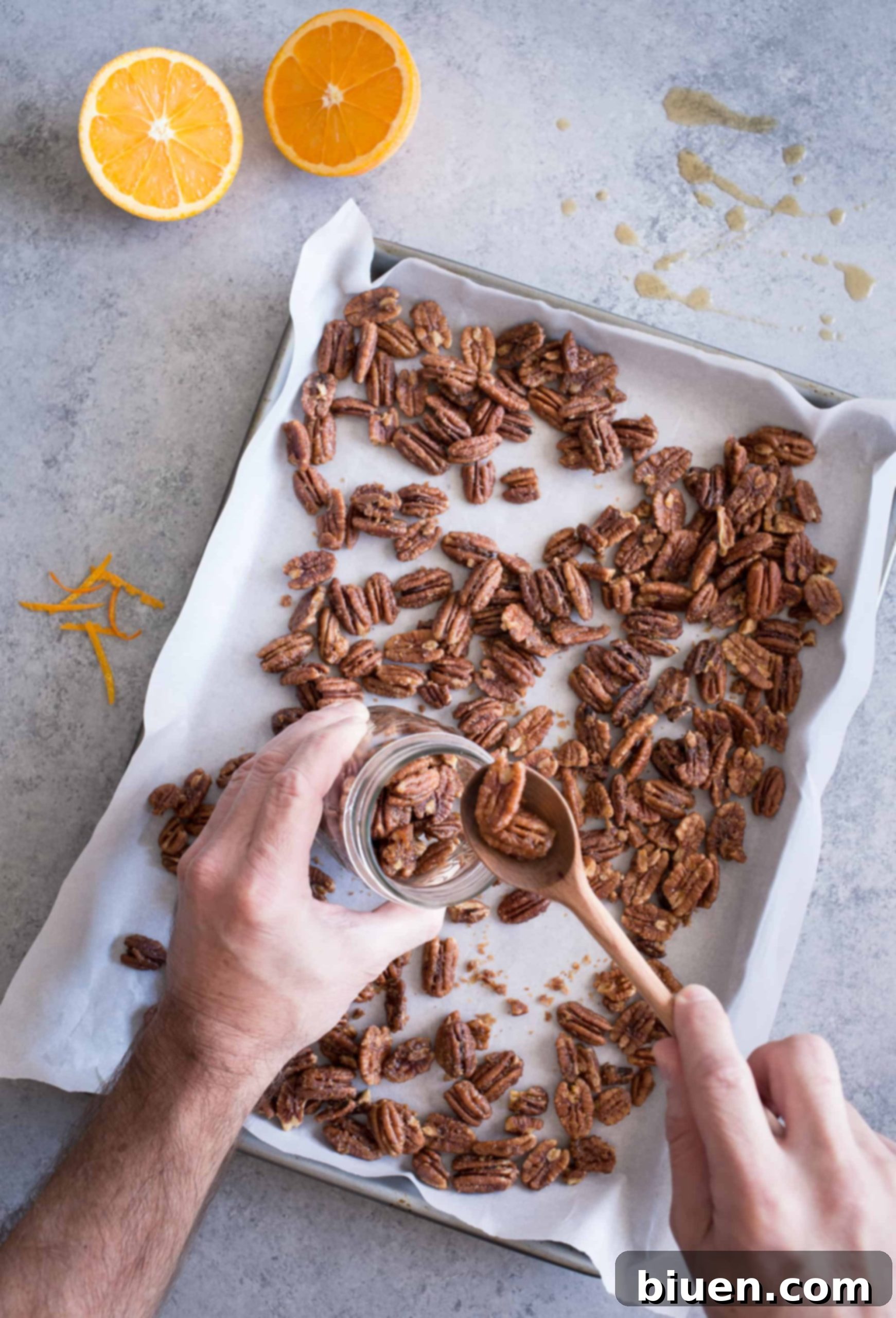 Maple-Orange Glazed Pecans 6 Maple-Orange Roasted Pecans spread in a single, even layer on a parchment-lined baking sheet, prepared for roasting.