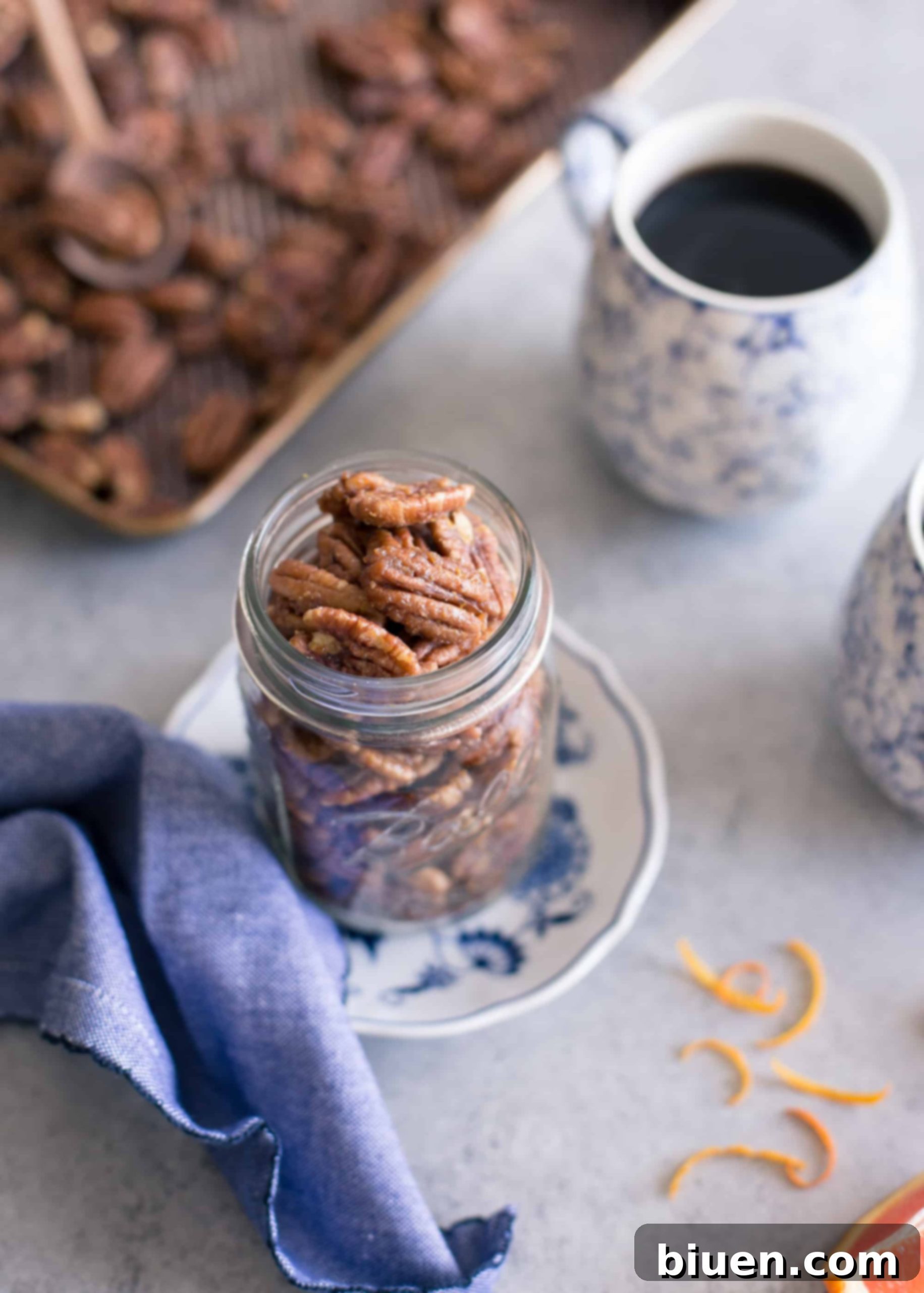 Maple-Orange Glazed Pecans 8 A stylish glass jar abundantly filled with freshly prepared Maple-Orange Roasted Pecans, ready for easy snacking.