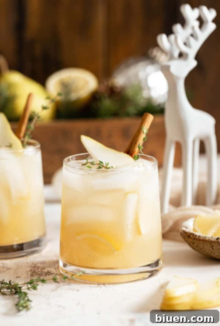 Spiced Pear Gin and Tonic 4 Spiced Pear Gin & Tonic in a double old-fashioned glass, garnished with a pear slice and thyme.