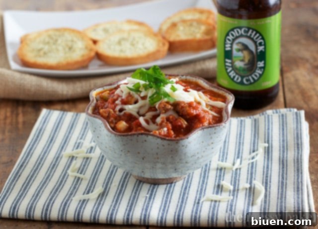 Serving suggestion for Slow Cooker Pizza Dip with a variety of dippers and garnishes.
