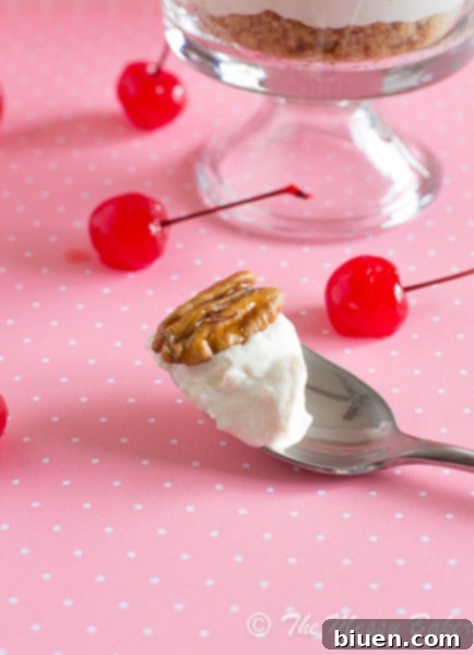 Delicious individual No-Bake Banana Sundae Cheesecake topped with whipped cream, wet pecans, and a maraschino cherry