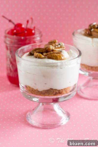 Exquisite No-Bake Banana Sundae Cheesecake in a jar, garnished with cherries and maple-glazed pecans
