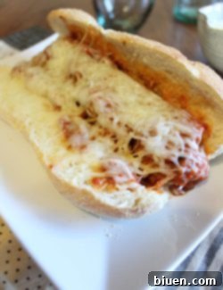 A plate of two hearty meatball subs with melted cheese and rich marinara.