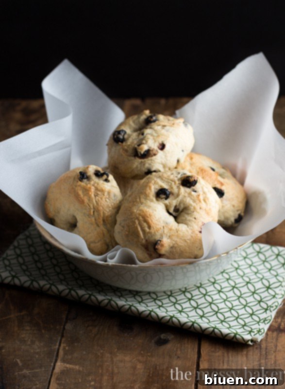 Hands demonstrating how to create the hole in Honey Wheat Blueberry Bagel dough
