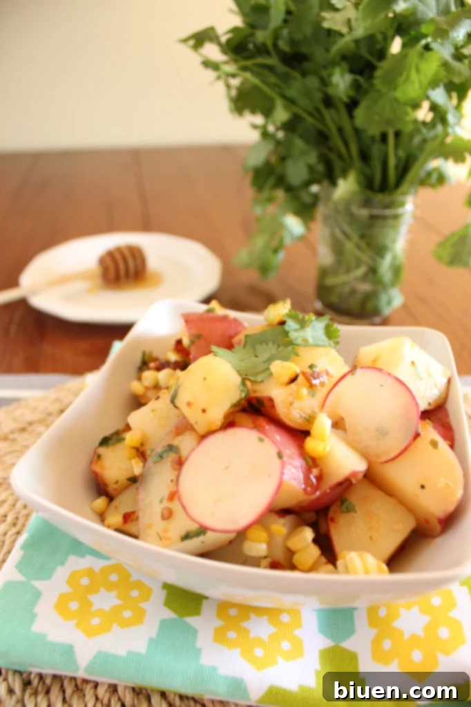 A vibrant close-up of the Red Potato and Grilled Corn Salad with the rich Chipotle Lime Vinaigrette glistening on top, ready to be tossed