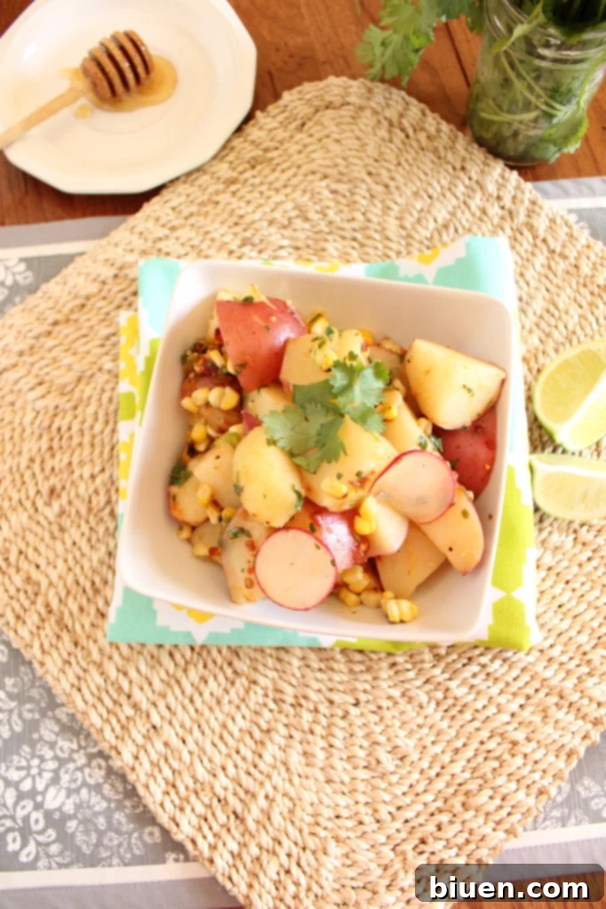A full bowl of the appetizing Red Potato and Grilled Corn Salad with Chipotle Lime Vinaigrette, ready to be served at a gathering