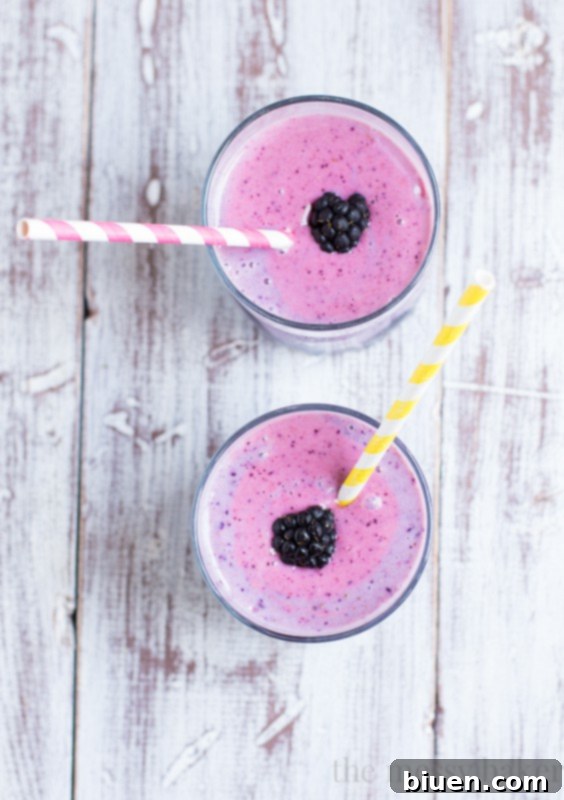 A glass of Summer Berry Smoothie on a rustic wooden surface
