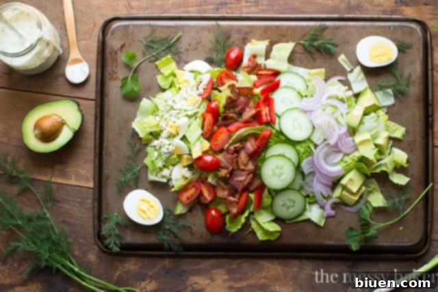 Garden Fresh Cobb Salad 3 Ingredients for a fresh Cobb Salad laid out, including vibrant romaine, grape tomatoes, and a variety of fresh herbs