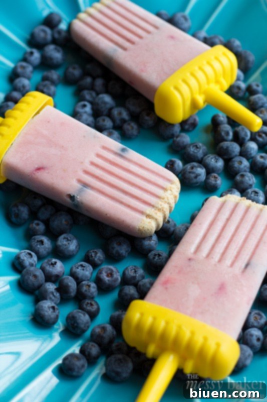 A Hand Holding a Fresh Strawberry-Banana Smoothie Popsicle