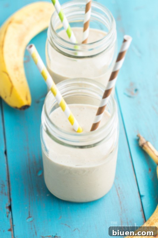 Wholesome PB Banana Oat Boost 6 A selection of ingredients for the peanut butter banana oat smoothie, including bananas, peanut butter jar, Greek yogurt, oats, and milk, arranged on a white surface.