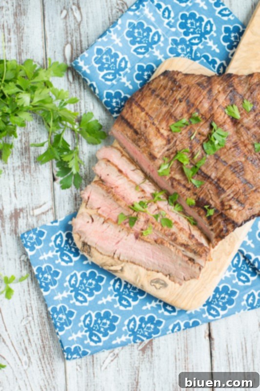 Grilled Tequila Chipotle Flank Steak marinating in a flavorful sauce.
