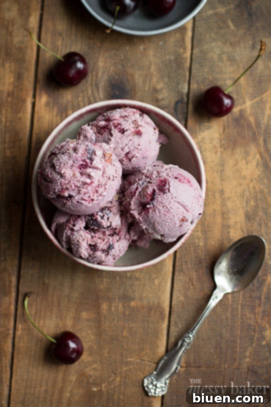 A tempting scoop of homemade cherry ice cream with almonds, nestled in a bowl, ready to be enjoyed.