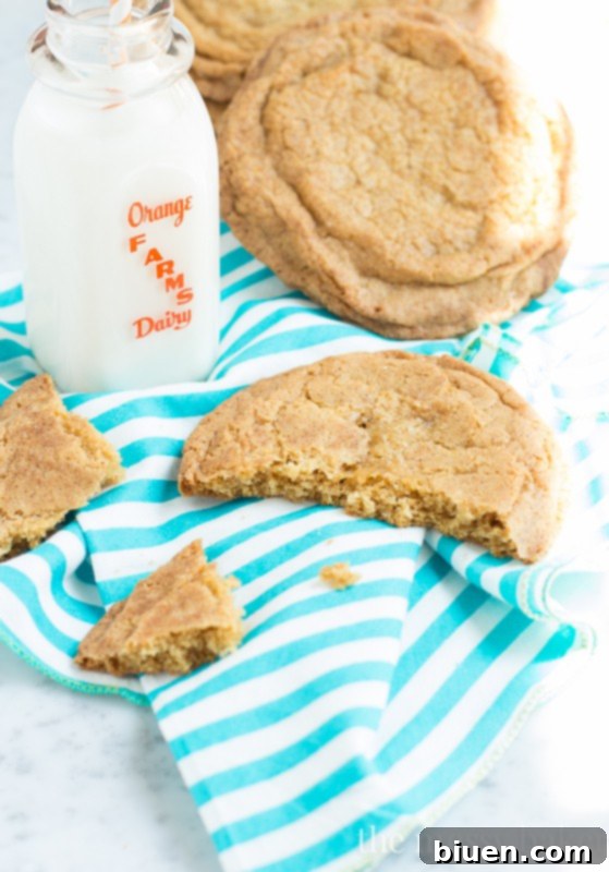 Close-up of a giant brown sugar snickerdoodle cookie, showing its soft interior and glistening cinnamon-sugar crust.