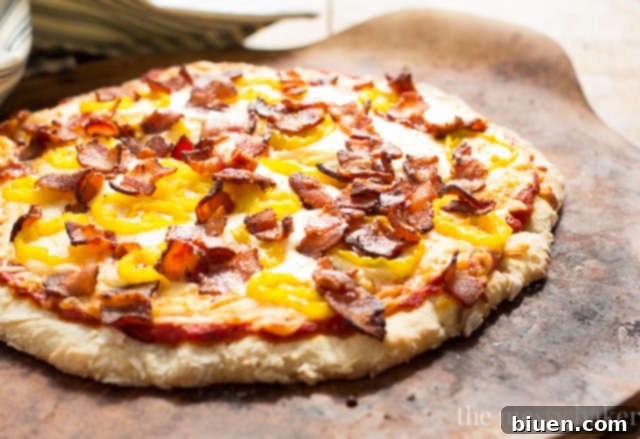 Zesty Gluten-Free Bacon Banana Pepper Pizza 8 A hand holding a slice of Gluten-Free Bacon Banana Pepper Pizza