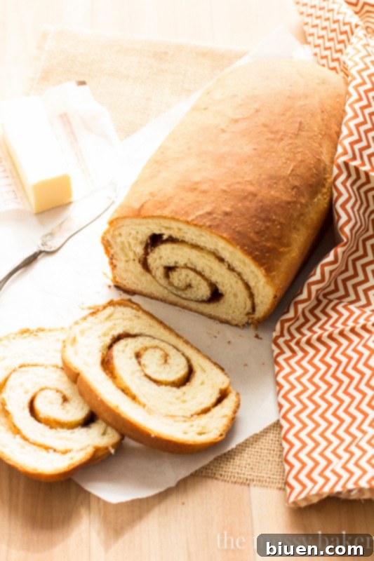 Close-up of a slice of Cinnamon Swirl Loaf, showcasing the rich, spiced pecan swirl and soft texture. The ultimate homemade sweet yeast bread. | www.themessybakerblog.com