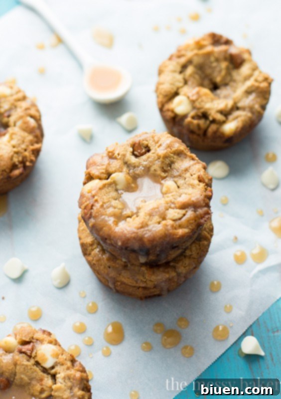 Guilt-Free Fall Indulgence: White Chocolate Pumpkin Cookie Cups 3 Gluten-Free White Chocolate Pumpkin Cookie Cups with Apple Cider Caramel drizzled on top, perfect for autumn baking.