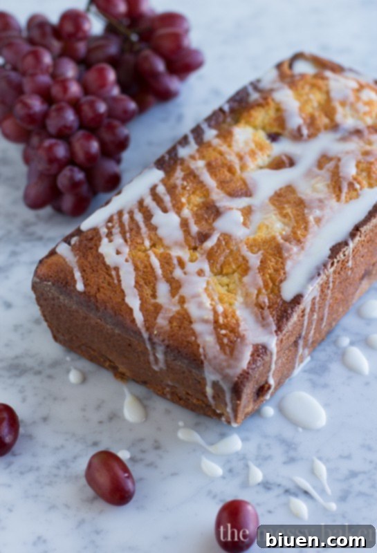 Sweet Grape Ricotta Pound Cake 5 A beautifully glazed slice of Ricotta Pound Cake with Grapes and Lemon Glaze, with a fork poised to take a bite, highlighting its inviting texture.