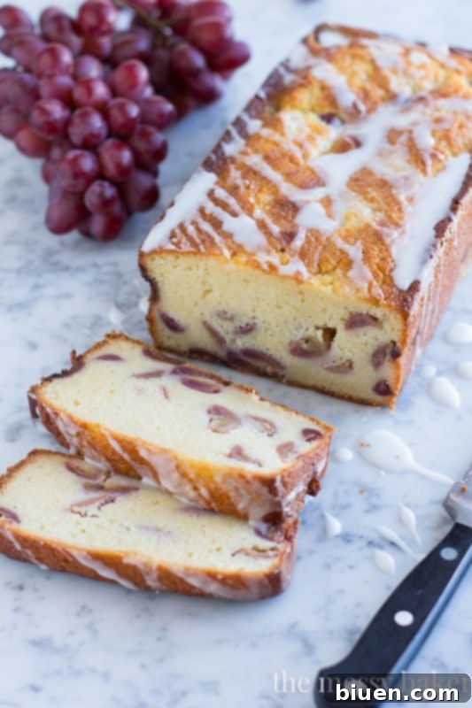 Sweet Grape Ricotta Pound Cake 6 Two generous slices of Ricotta Pound Cake with Grapes and a lavish drizzle of Lemon Glaze, invitingly placed on a white plate, ready to be enjoyed with coffee or tea.