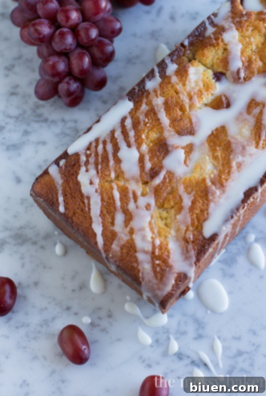 Sweet Grape Ricotta Pound Cake 8 A close-up shot of a thick slice of Ricotta Pound Cake with Grapes and Lemon Glaze, highlighting the moist texture, even distribution of grapes, and the glossy glaze.