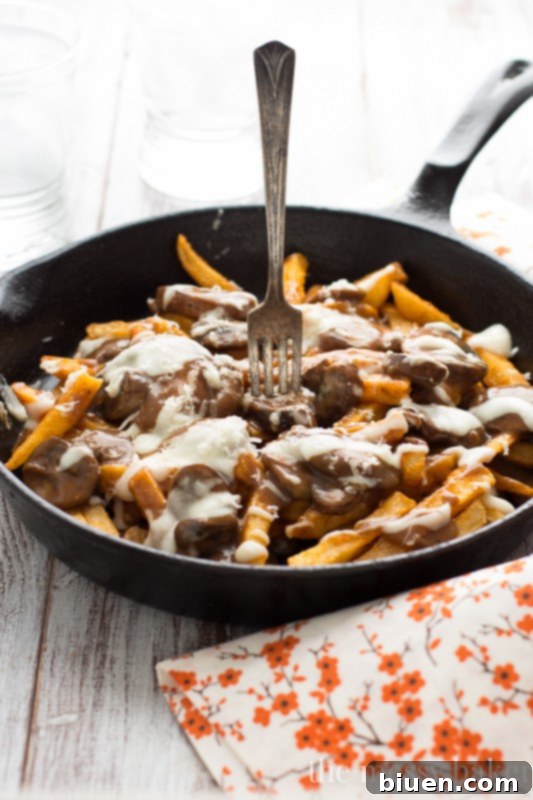 Gluten-Free Mushroom Swiss Poutine | A close-up of the poutine, emphasizing the delicious textures and golden fries.
