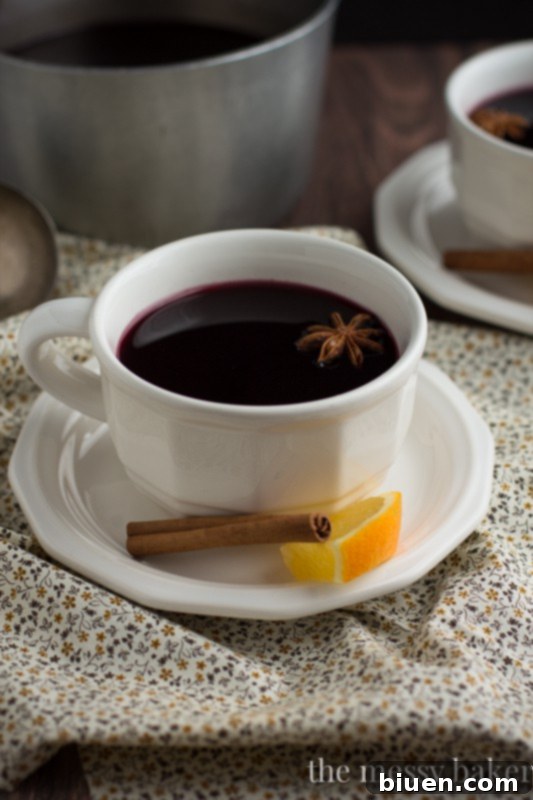 Pomegranate Mulled Wine in a clear mug, showing its rich color and garnishes