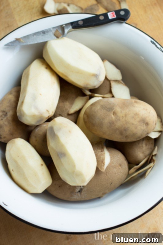 Various kitchen tools for mashing potatoes, including a classic hand masher and an electric stand mixer.